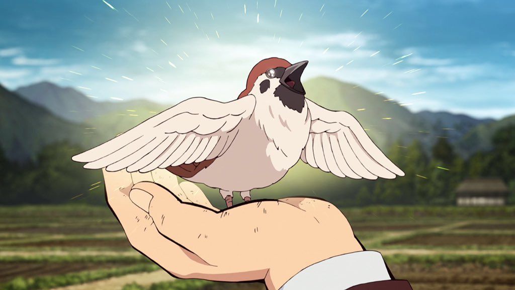a human hand holding a bird with open beak